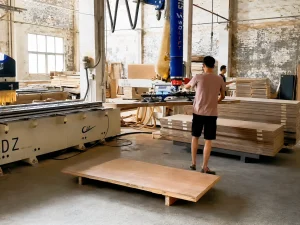 WOLIFT column-mounted jib crane covering wooden board stacks and CNC machining center