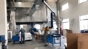 WOLIFT pneumatic vacuum tube lifter on a jib crane handling fertilizer bags in a production line