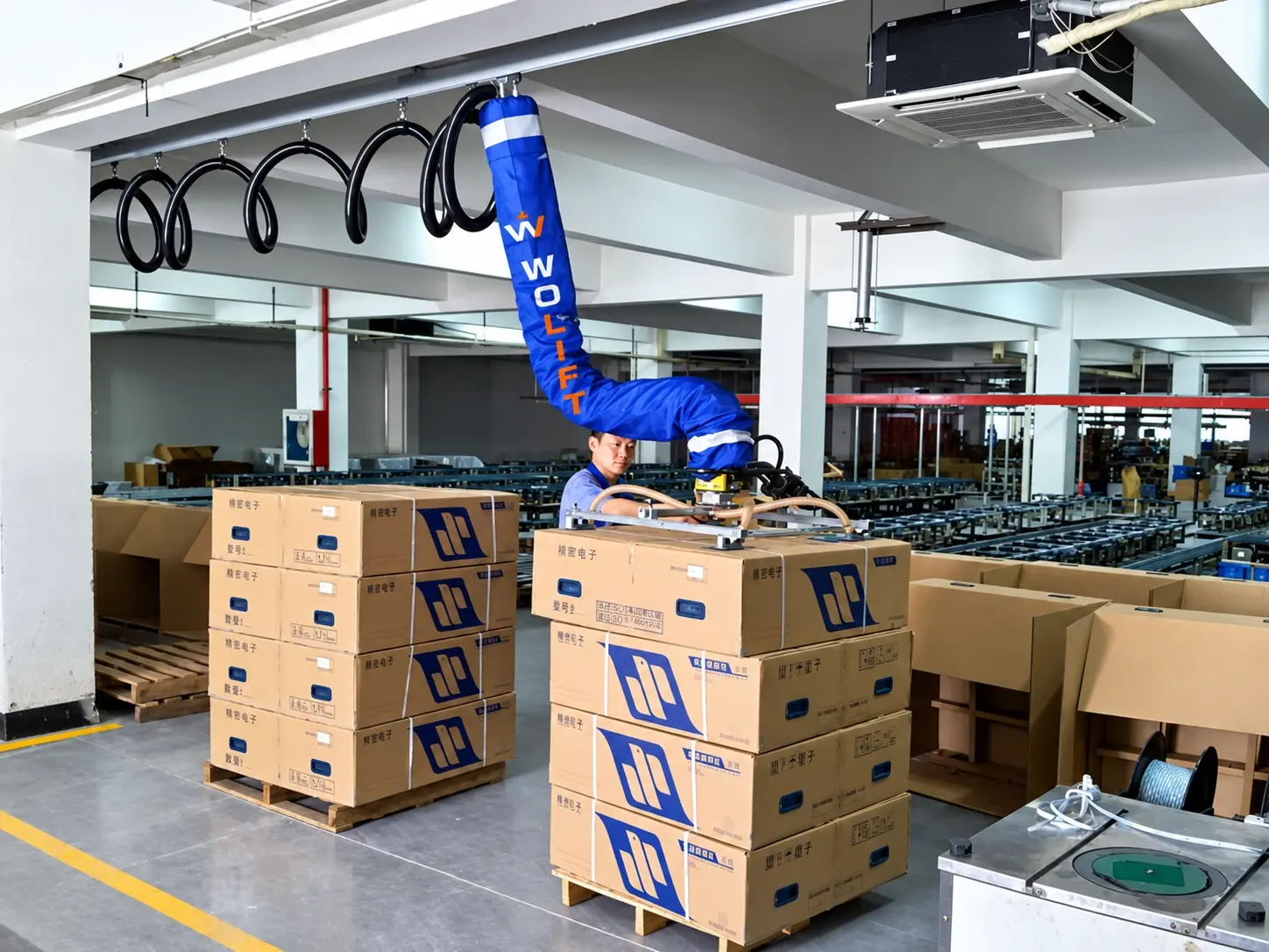 WOLIFT vacuum tube lifter assisting carton depalletizing in a warehouse